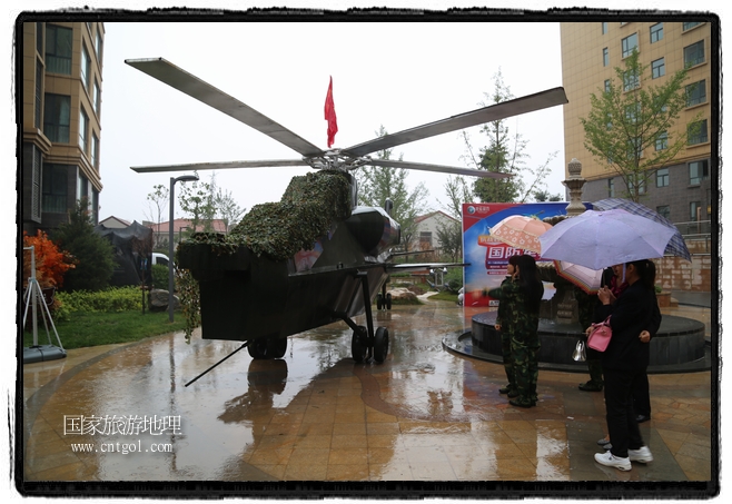 小區(qū)突然出現(xiàn)“飛機(jī)坦克”，其中殲15艦載戰(zhàn)斗機(jī)一架、99式主戰(zhàn)坦克一輛、武直-10武裝直升機(jī)一架，吸引了眾多市民雨中圍觀、合影。